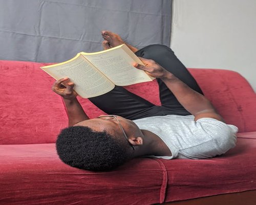 Man relaxing on a comfortable sofa reading a book